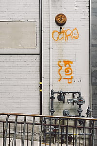 gray metal pipe mounted on white concrete wall thumbnail