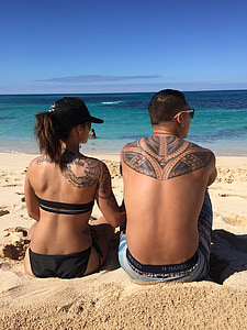 man and woman sitting in front of seashore thumbnail