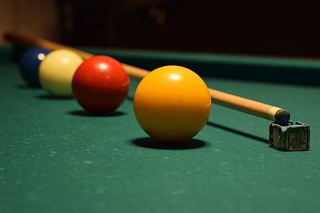 pool balls and cue stick on green pool table thumbnail