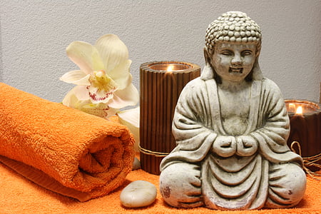Buddha figurine near candle holders thumbnail