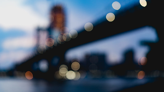 person taking blurry photo of black suspension bridge during daytime thumbnail