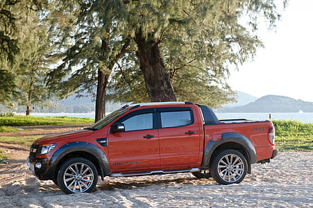 orange Ford Ranger crew cab pickup truck parked near trees at daytime thumbnail