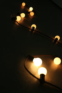 yellow string lights lighted up on dark floor thumbnail