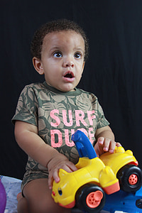 toddler holding yellow plastic toy truck thumbnail