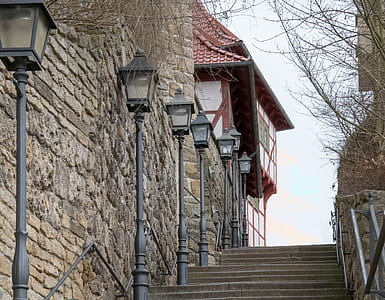 black metal post lights near red roof house thumbnail