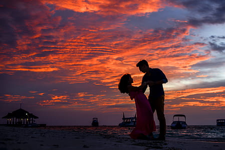 Man and Woman on Beach during Sunset thumbnail