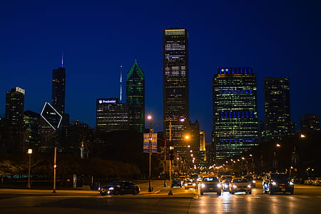 assorted vehicle passing by over high-rise building at night thumbnail