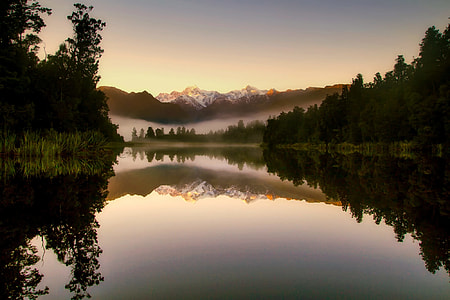 landscape reflection photography of pine trees under sky background thumbnail