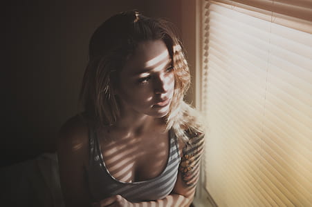 woman wearing gray tank top near window blinds thumbnail