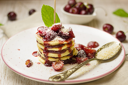 yellow pancakes with cherries on top thumbnail