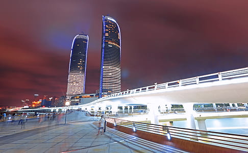 people waking near tall building at night thumbnail