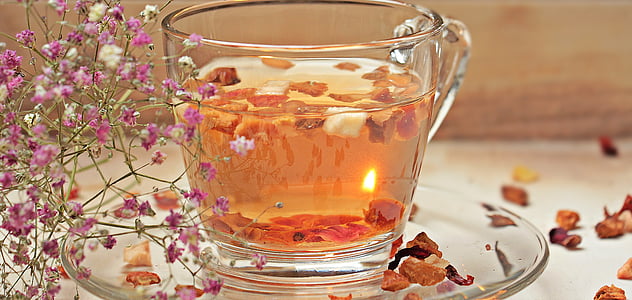 photo of filled clear glass teacup with saucer and flower petals thumbnail