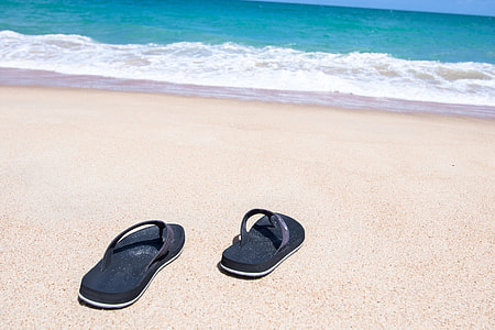 pair of black flip-flops in seashore thumbnail