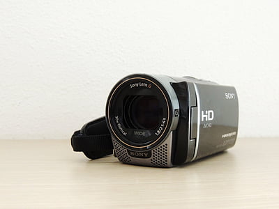 black and grey Sony Handycam on beige wooden surface thumbnail
