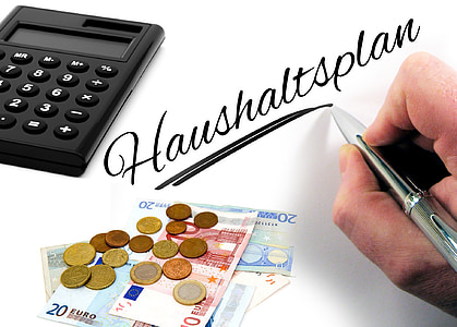 person writing Haushaltsplan beside calculator thumbnail