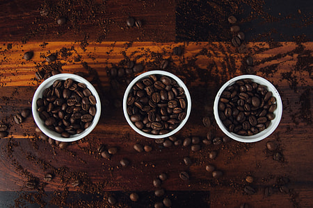 Three cups with coffee beans in them on a wooden table thumbnail