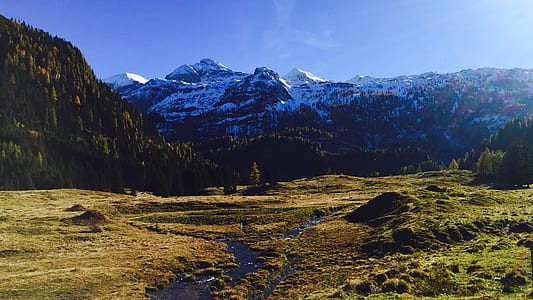 grass field across mountain during daytime thumbnail