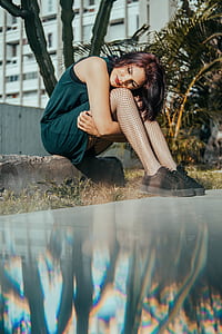 woman sitting while hugging her legs thumbnail