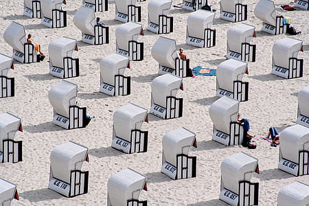 close up photo of white benches with shed on beach thumbnail