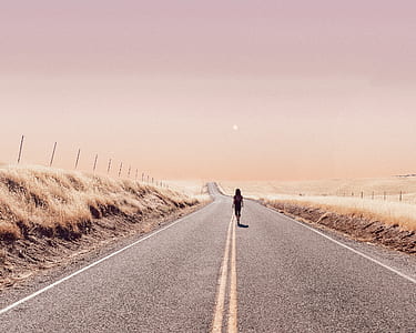 person walking in road during daytime thumbnail