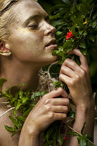 person holding green leafed branch with red petaled flower thumbnail