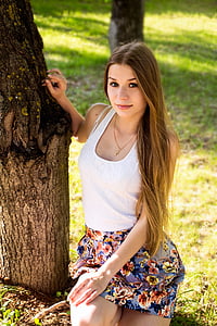 woman in white tank top standing beside tree thumbnail