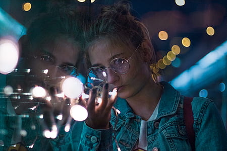 woman wears denim jacket holds lighted bulb thumbnail