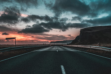 gray asphalt road surrounded by brown mountains thumbnail
