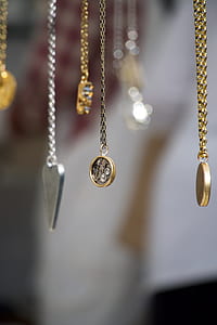 shift lens photography of gold-colored and silver-colored heart and round pendants thumbnail