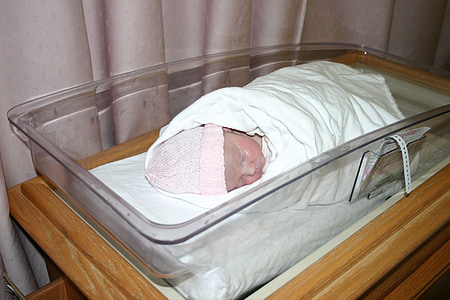 baby lying on clear plastic crib thumbnail
