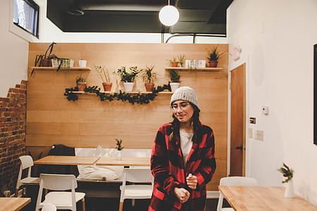 woman standing beside brown wooden table thumbnail