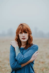woman wearing grey shirt standing on green and brown field thumbnail
