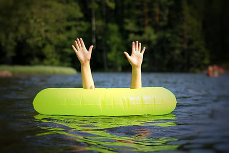 person swimming on body of water thumbnail