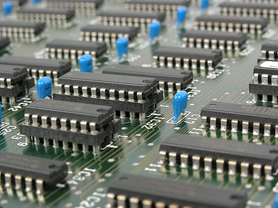 Black and Blue Electronic Tools on Green Circuit Board thumbnail