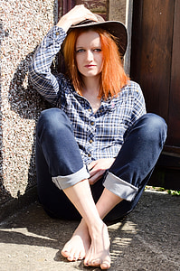 woman sitting on corner holding her brown leather hat thumbnail
