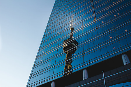 brown statue reflect on blue glass high rise building thumbnail