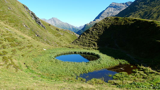 aerial view photography of fish pond near mountain thumbnail