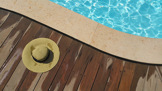 brown hat on brown wooden floor beside pool thumbnail
