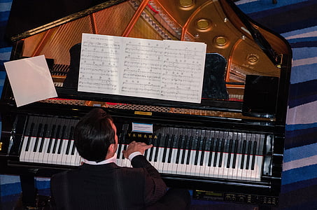 man playing upright piano thumbnail