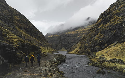 photo of three person standing near mountain thumbnail