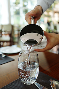 person pouring water from pitcher thumbnail