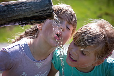 two girls drinking water during daytime thumbnail
