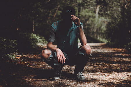 man sitting on brown soil during daytime thumbnail