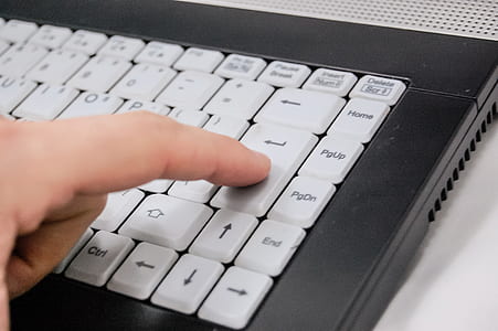 person pressing enter of black and white laptop computer thumbnail