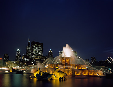 brown and white fountain near high buildings at nighttime thumbnail