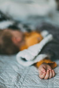 baby lying down on bed thumbnail