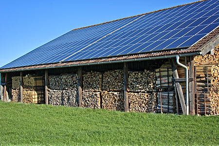 pile of brown lumbers above row of solar water panels thumbnail