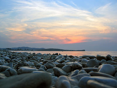 black pebbles near ocean during golden hours thumbnail