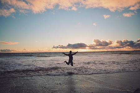 Person Taking Picture in Seashore during Sunset thumbnail