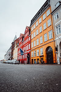 assorted-color concrete buildings under gray sky thumbnail
